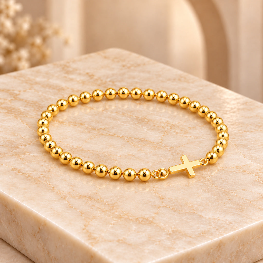 Pulsera Cruz acostada sobre mármol claro